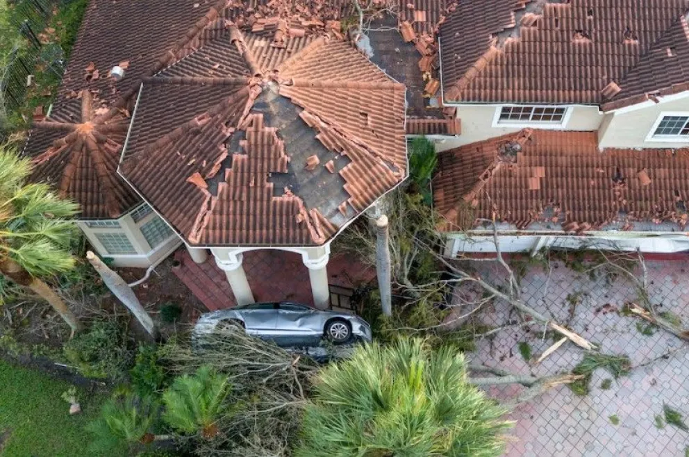 Increíble. El huracán Milton provocó en esta vivienda el vuelco y destrucción de un automóvil de alta gama, como destrozos en el techo de la casa.