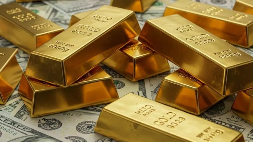 lingotes de oro sobre billetes de dólar