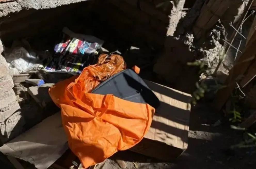 Tapada. La MacBook escondida, dentro de una bolsa de color naranja, en la parte inferior de un parrillero.