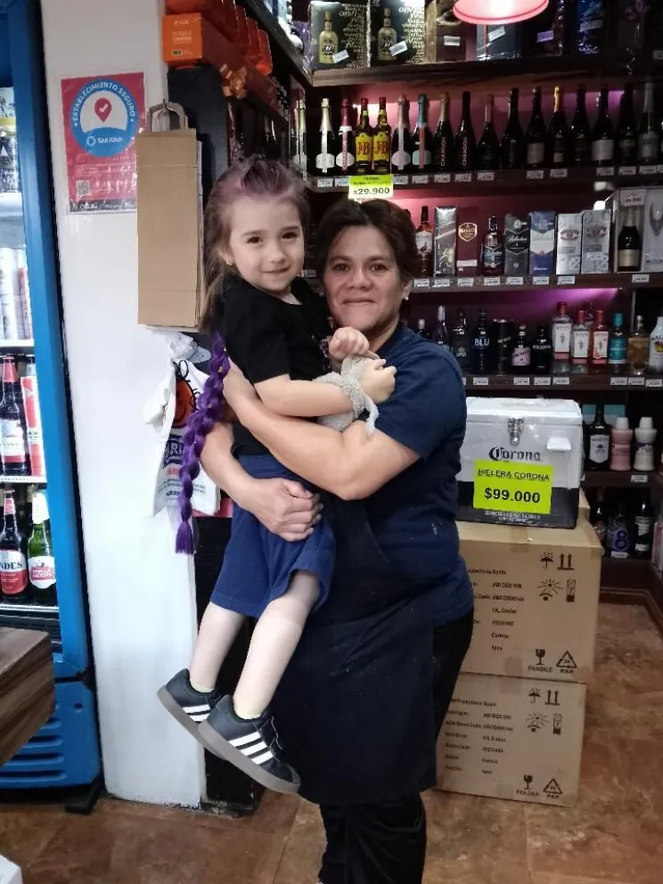 Feliz. Nina, junto a la empleada del Patio Alvear, que encontró el peluche en el centro comercial.