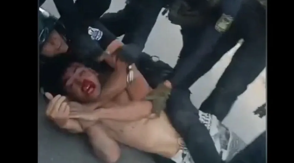 Detenido. Uno de los hermanos Oro, en el piso, retenido por un policía, en la Villa Santa Anita.