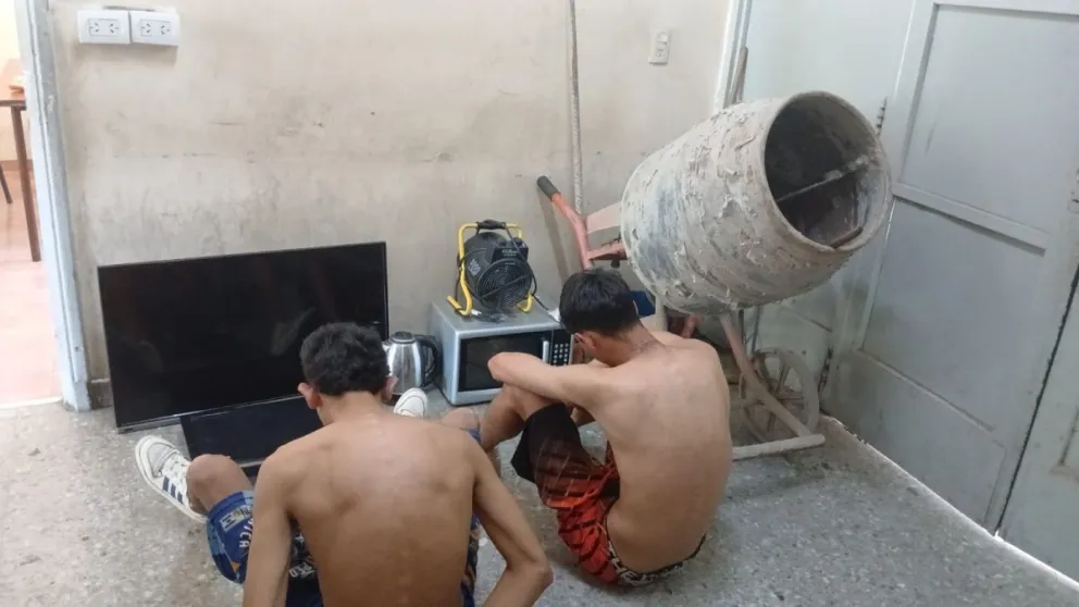 Capturados y el botín. Los dos sujetos mayores, junto a los objetos que robaron de un complejo de cabañas.