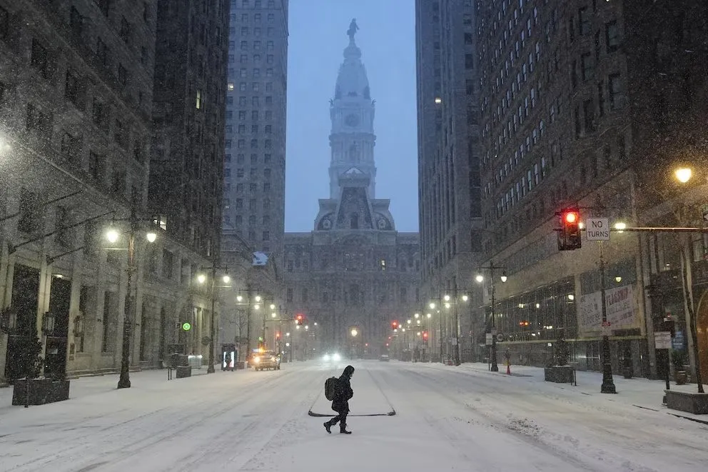 Una persona cruza una calle durante una tormenta invernal en Filadelfia, el domingo 25 de enero de 2026.