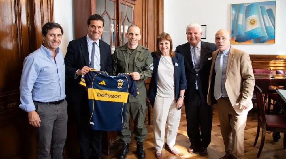 Nahuel Gallo, junto a Patricia Bullrich, y otros funcionarios, con la camiseta de Boca que le obsequiaron.