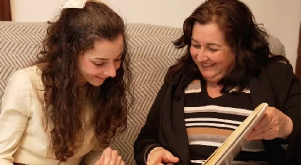 Noelia Castillo Ramos, la joven parapléjica que recibirá la eutanasia, viendo un álbum de fotos junto a su madre, Yolanda Ramos.