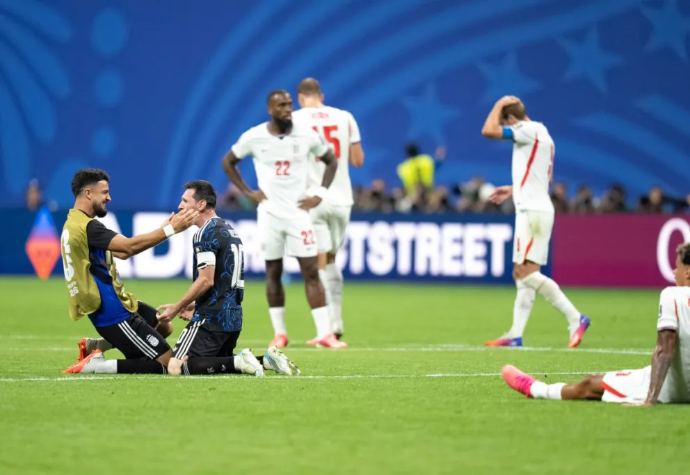 Leo Messi se arrodilla y celebra con el Flaco López el pase a la gran final ante España. Los ingleses se lamentan.