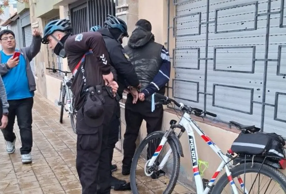 El malviviente, de apellido Guzmán, siendo esposado por policías.